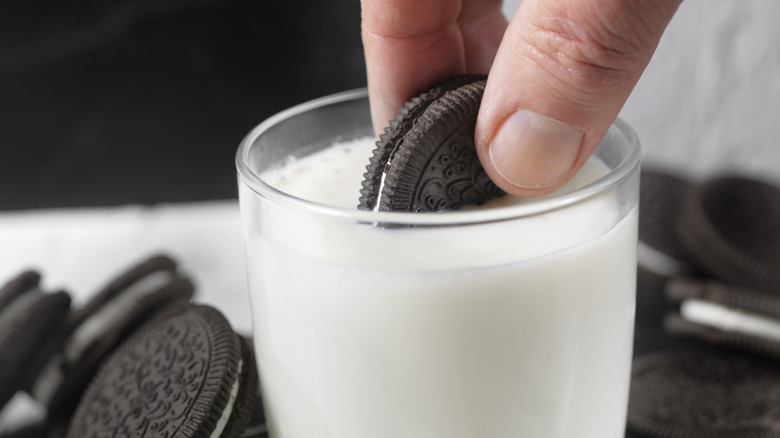 Oreo being dipped in milk