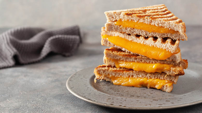 Cheddar grilled cheese stacked on plate