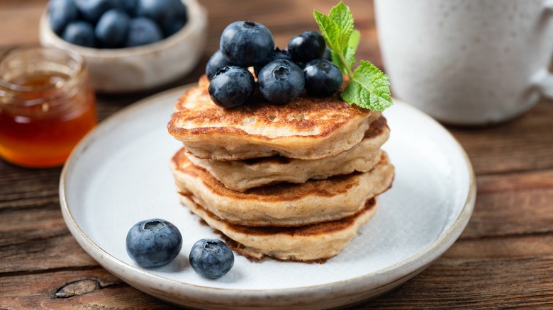 Oatmeal and banana blueberry pancakes on plate garnished with fresh blueberries..