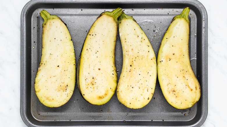 seasoned eggplant halves in pan