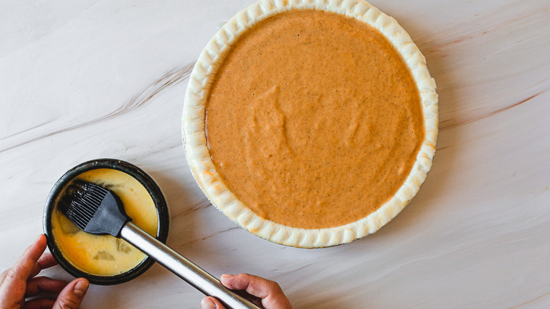 brushing edges of pumpkin pie 