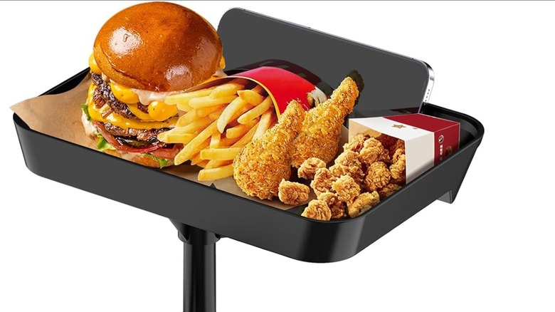 Burger, fries, chicken wings, chicken bites, phone on black tray