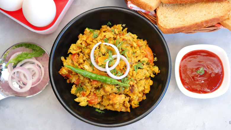 bowl of egg bhurji with sauce and bread