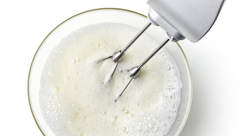 foaming egg whites in a mixing bowl