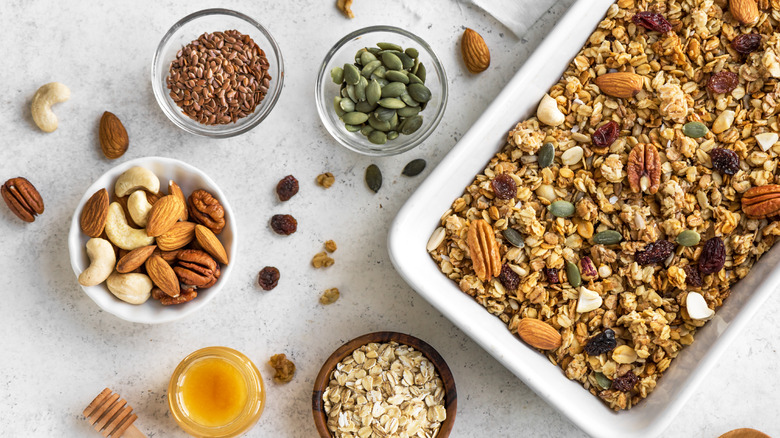 granola surrounded by nuts and seeds