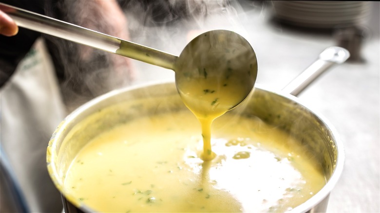 Ladle pouring creamy soup 