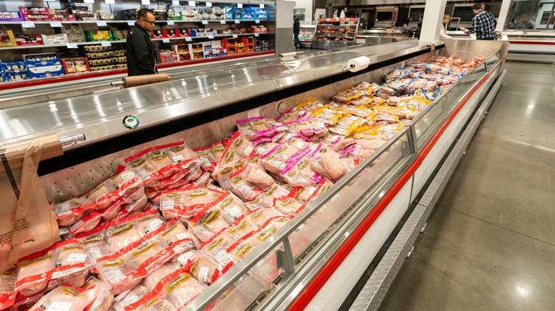 costco's poultry section with chicken breasts in foreground