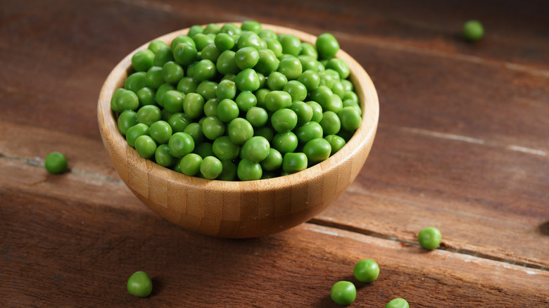 Green peas in wooden bowl