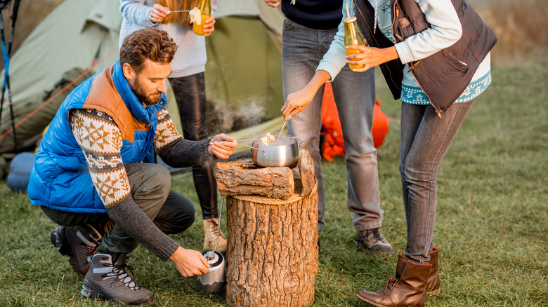 Campers enjoying wood-fired fondue