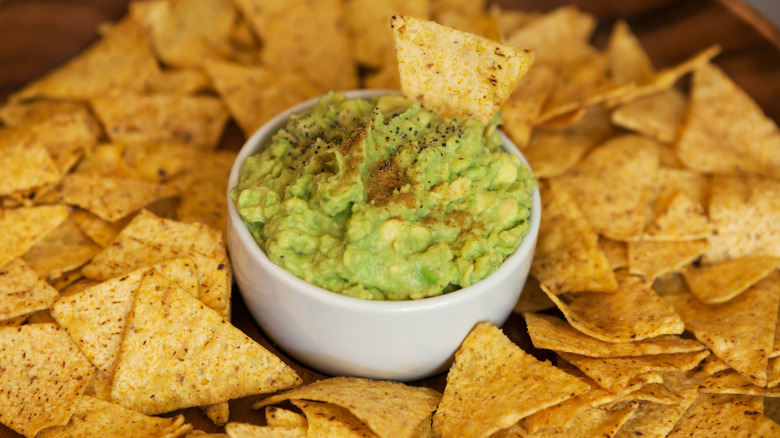Bowl of guacamole surrounded by chips