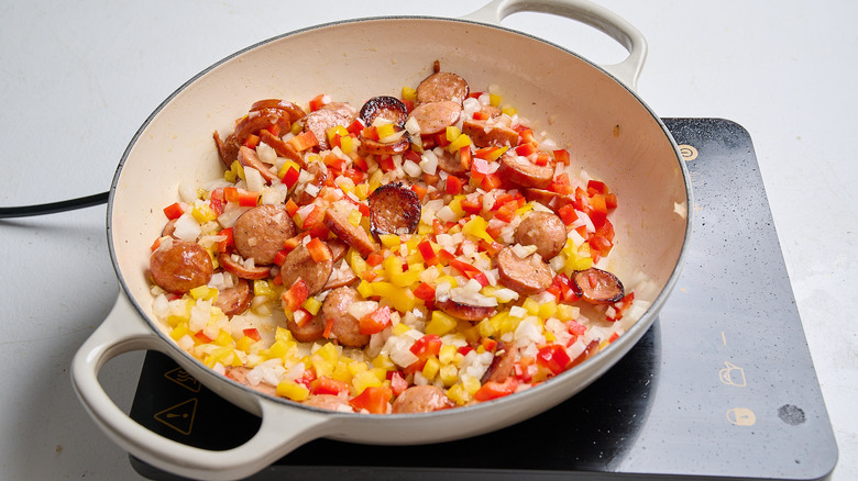 cooking vegetables with sausage in a skillet