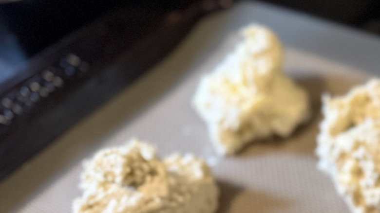 Mounds of biscuit dough on a cookie sheet