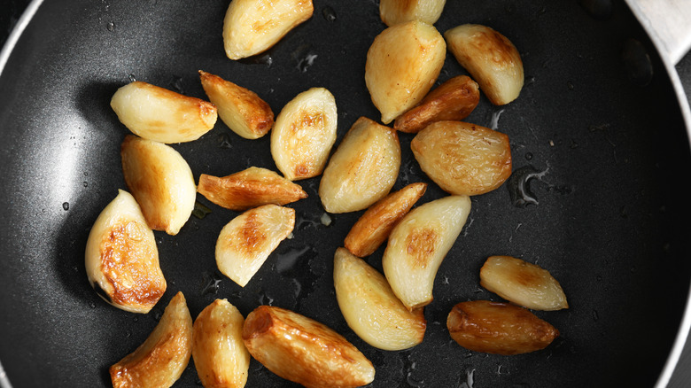 Caramelized garlic cloves in frying pan