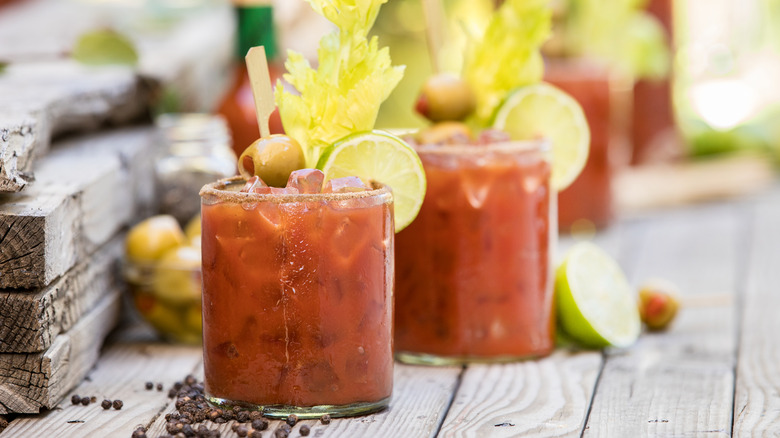 Two glasses of Bloody Mary on a wooden table