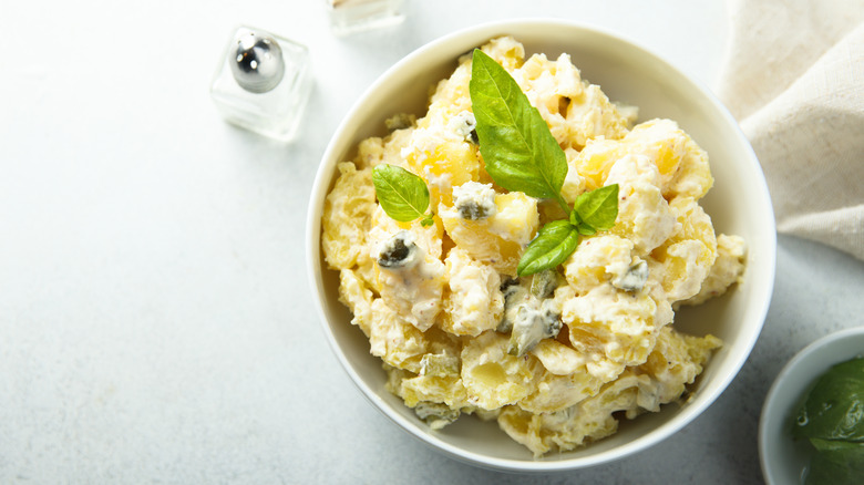 Creamy potato salad garnished with basil