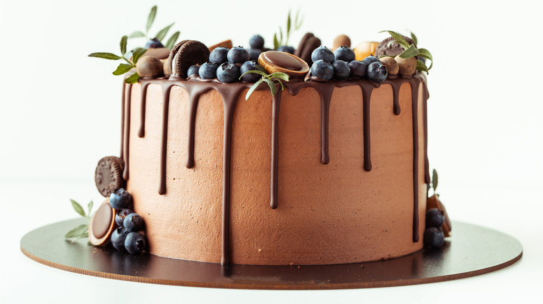chocolate layered cake with blueberries and chocolate drip