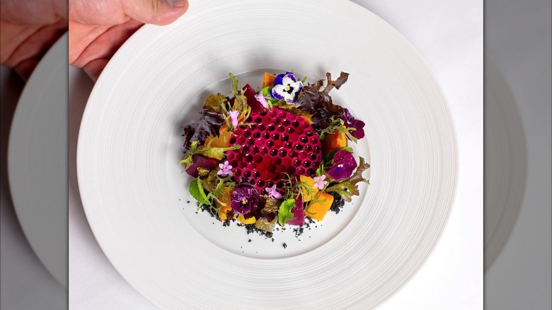 Plate with edible flowers and red honeycomb