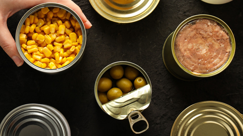 Different types of canned foods on a black table