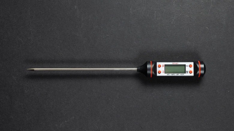 Battery-operated digital thermometer on a black table