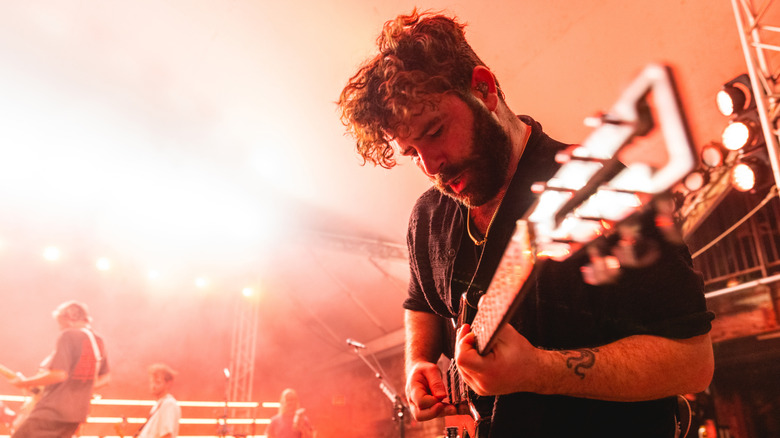 Man performing music on stage guitar