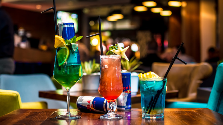 Three cocktails with Red Bull sitting on a bar top