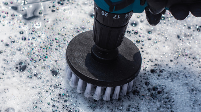 Power drill creating suds and cleaning a textured surface