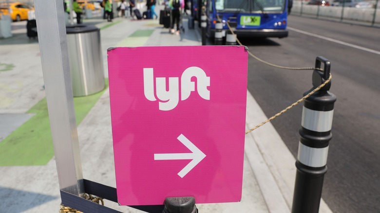 Pink Lyft sign on sidewalk