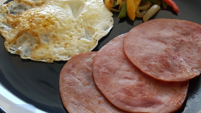 Plate of Canadian bacon and fried eggs