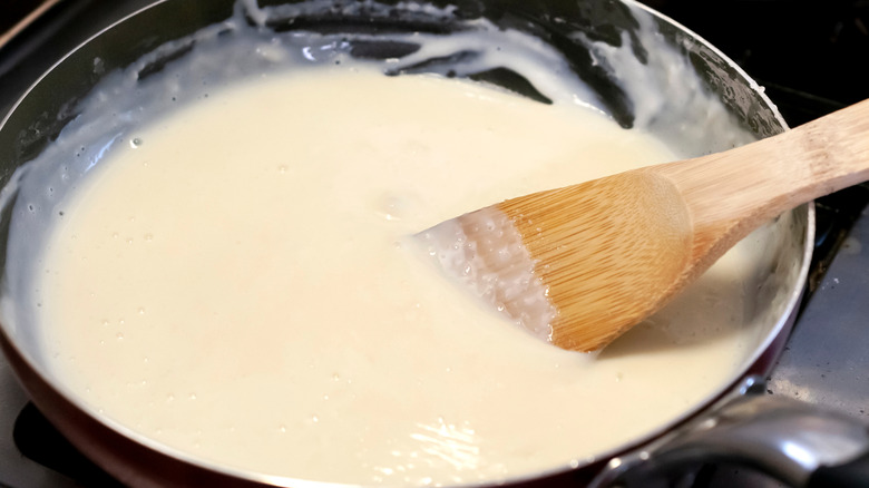 wooden spatula stirring Bechamel sauce