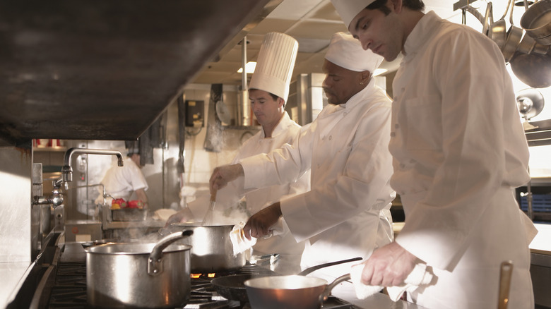 Multiple cooks making sauces