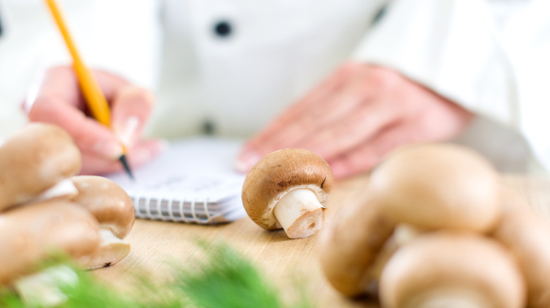 Chef making notes around mushrooms