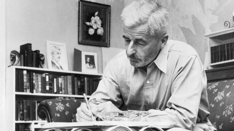 Photo of William Faulkner writing at a table