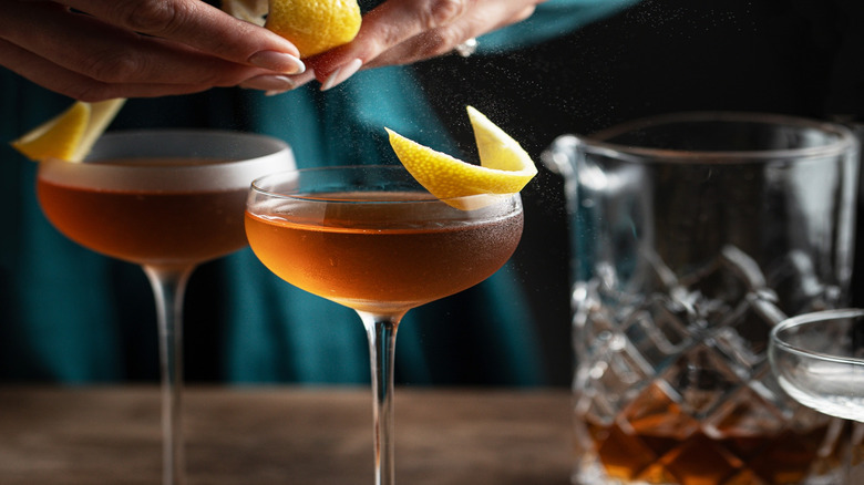 Lemon spritzing into a coup glass.