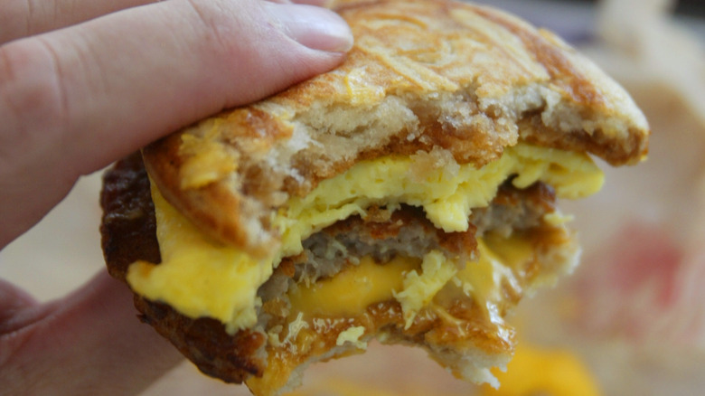 holding McDonald's breakfast sandwich