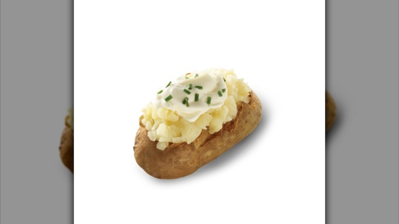 a Wendy's baked potato with sour cream and chives against a white background