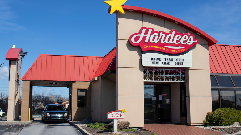 Hardee's restaurant exterior, with a black car in its drive thru lane