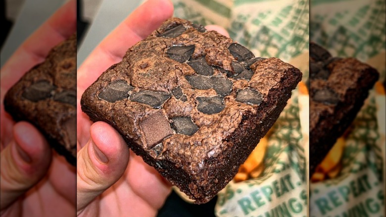 A hand holds a Wingstop Triple Chocolate Chunk Brownie
