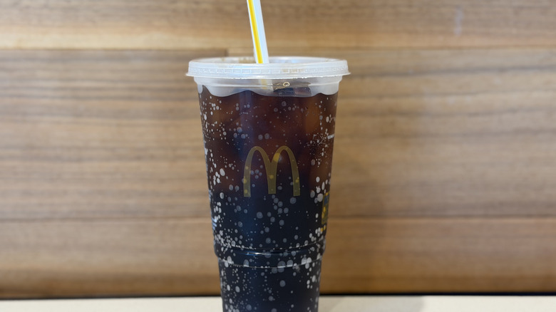 A plastic McDonald's cup against a wood background
