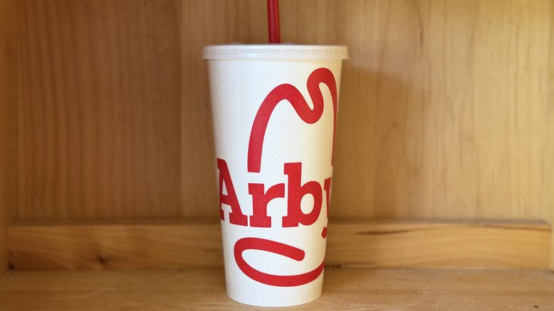 A paper Arby's cup against a wood background