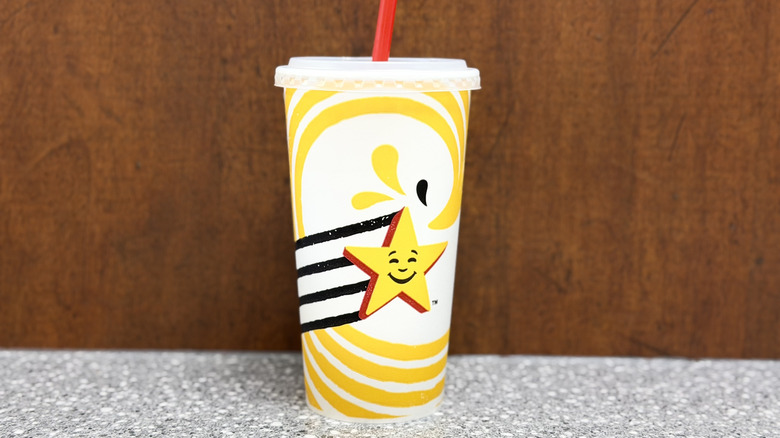 A paper Carl's Junior cup against a brown background