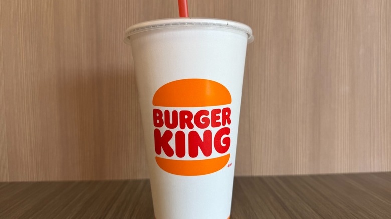 A paper Burger King cup against a wood grain background