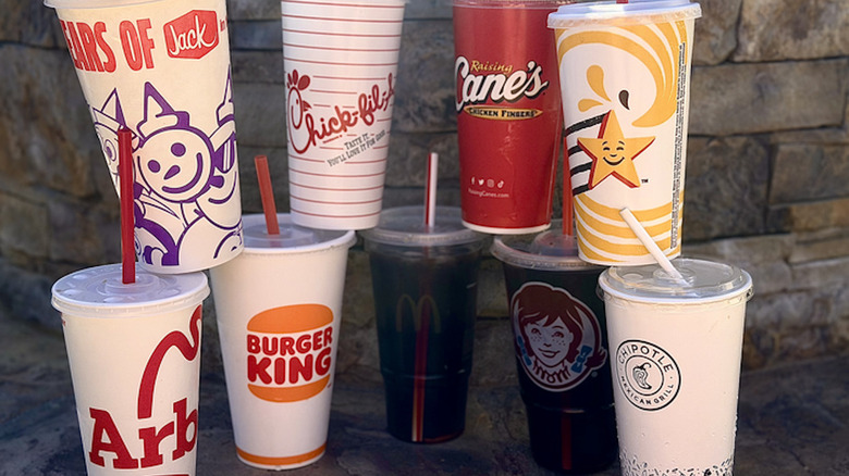 Fast food cups stacked against a grey slate background