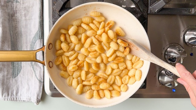 Potato gnocchi browning in skillet on stovetop