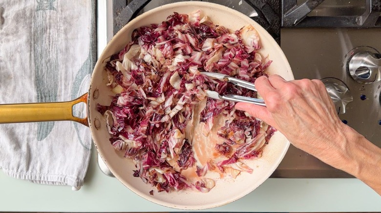 Charring radicchio with fig juices in white skillet on stovetop