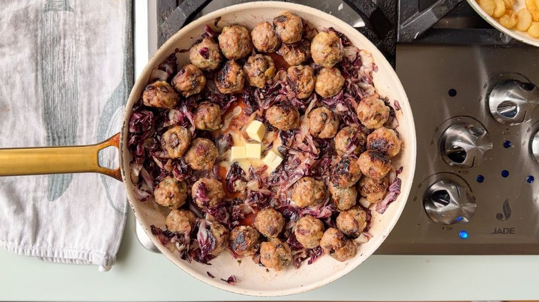 Butter cubes in center of skillet with fig and gorgonzola meatballs and charred radicchio