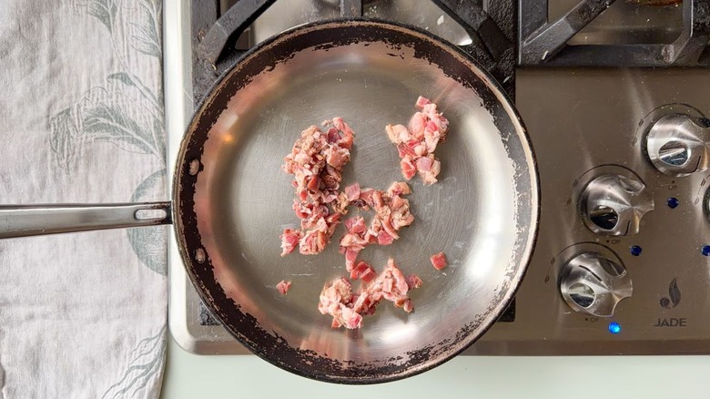 Chopped raw bacon in skillet on stovetop