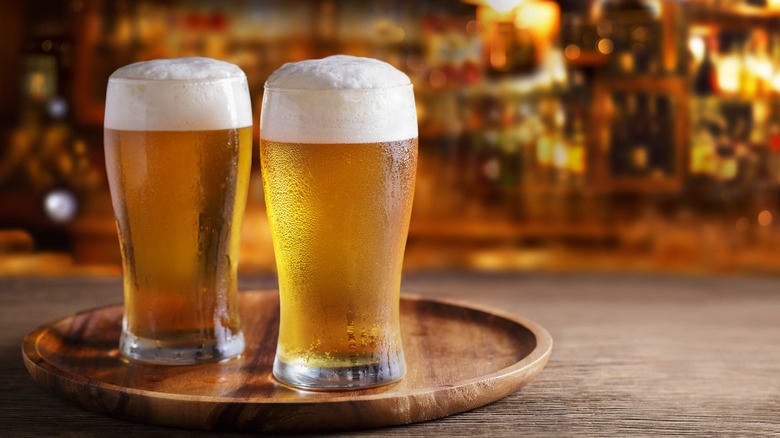 two beer glasses on a bar