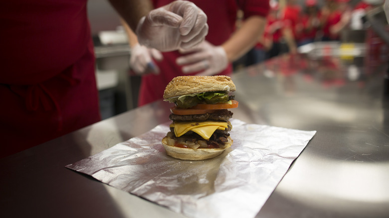 Five Guys worker preparing cheeseburger