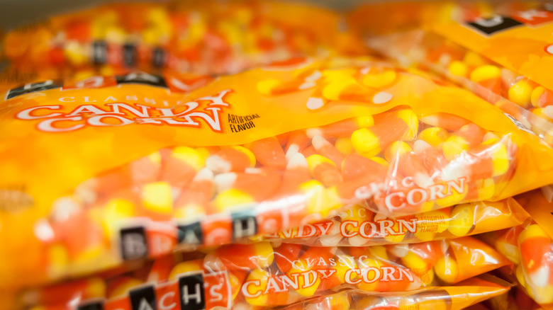 A closeup of bags of Brach's candy corn stacked atop one another.