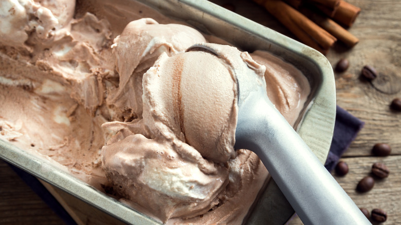 A metal container of ice cream with an ice cream scoop